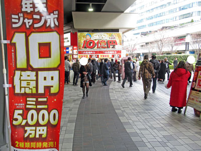年末ジャンボ10億円のノボリの奥には多くのお客さんで賑わう有楽町駅大黒天売場